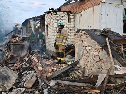 رجال الإطفاء يزيلون الأنقاض من المنازل في ضواحي خاركيف الأوكرانية التي دمرها هجوم الطائرات الروسية المسيرة، 21 مايو 2024 - AFP