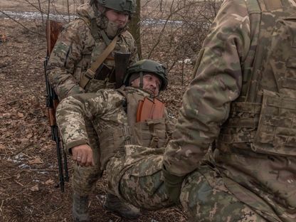 جنود أوكرانيون يجلون جندياً مصاباً في منطقة دونيتسك شرقي أوكرانيا. 31 يناير 2024 - AFP
