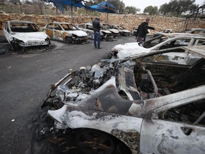 سيارات محروقة في وكالة لبيع السيارات قام مستوطنون إسرائيليون بإضرا النار فيها. الضفة الغربية، فلسطين. 23 يناير 2024 - AFP