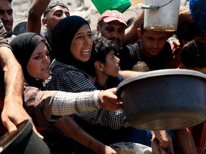 فلسطينيون يتجمعون لتلقي الطعام من مطبخ خيري، وسط أزمة جوع في مدينة غزة. 25 يوليو 2025 - Reuters