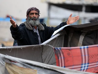 رجل فلسطيني يقف وسط الخيام أثناء أمطار على مدينة غزة. 14 نوفمبر 2025 - REUTERS