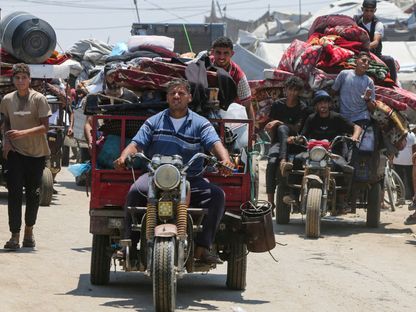فلسطينيون نازحون يشقون طريقهم نحو منطقة المواصي وسط هجوم بري إسرائيلي، في خان يونس في جنوب قطاع غزة. 10 يوليو 2025 - Reuters