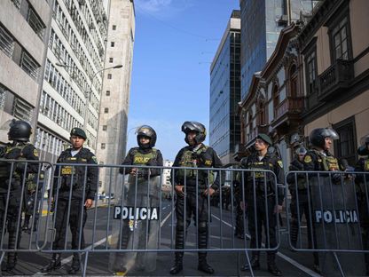 ضباط الشرطة يقفون في حراسة خارج مبنى المدعي العام في العاصمة البيروفية ليما. 5 أبريل 2024، قبل وصول الرئيسة دينا بولوارتي. - AFP