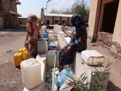 سودانيات يملأن عبوات بلاستيكية بالمياه النظيفة في مركز إيواء للنازحين بمدينة بورتسودان بولاية البحر الأحمر شرق السودان. 31 أكتوبر  2024 - Asharq