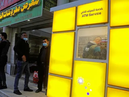 موظفو السلطة الفلسطينية ينتظرون استلام رواتبهم خارج أحد البنوك في الضفة الغربية المحتلة. 3 ديسمبر 2020 - REUTERS