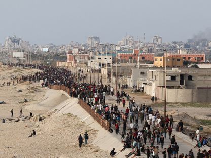 فلسطينيون يتجمعون على أمل الحصول على مساعدات يتم تسليمها إلى غزة من خلال رصيف بنته الولايات المتحدة. 19 مايو 2024 - Reuters