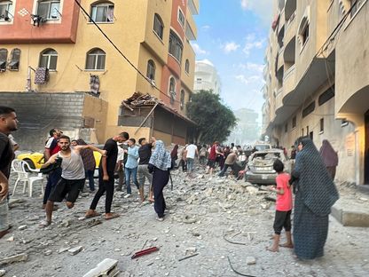 فلسطينيون يبحثون عن ناجين أو ضحايا في أعقاب قصف إسرائيلي على مخيم النصيرات بوسط قطاع غزة. 29 أغسطس 2024 - Reuters