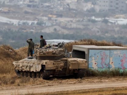 جنود إسرائيليون أعلى دبابة على حدود قطاع غزة بينما يستمر القصف والغارات الجوية. 25 أبريل 2024 - Reuters