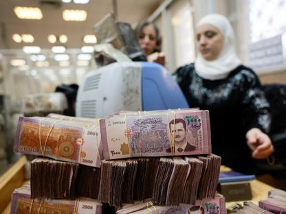 رزم من الأوراق النقدية السورية بينما تقوم موظفة بعدّ النقود في البنك المركزي السوري في دمشق. 16 ديسمبر 2024 - reuters
