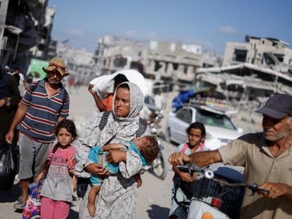 فلسطينيون في طريقهم للعودة إلى أحياء في الجانب الشرقي من خان يونس جنوب قطاع غزة. 30 يوليو 2024 - REUTERS