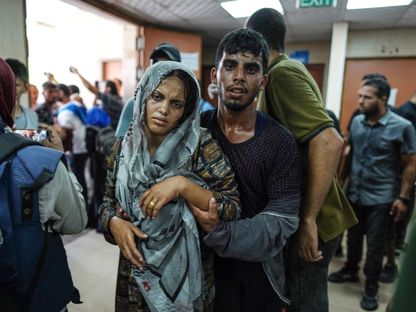 رجل يساعد امرأة مصابة جراء قصف إسرائيلي عند وصولها إلى مستشفى شهداء الأقصى في دير البلح وسط قطاع غزة. 8 يونيو 2024 - AFP