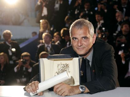 المخرج الفرنسي لوران كانتيه يحتضن  جائزة السعفة الذهبية في مهرجان كان السينمائي. 25 مايو 2008 - AFP
