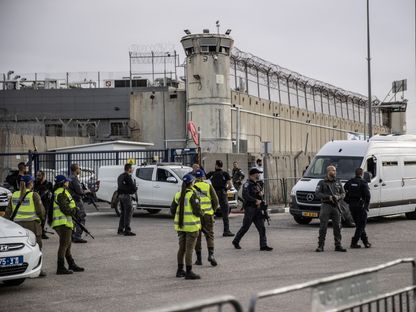 عناصر أمن إسرائيليون يتخذون إجراءات لنقل فلسطينيين إلى سجن عوفر في الضفة الغربية بموجب اتفاق تبادل محتجزين وأسرى مع حركة حماس. 25 نوفمبر 2023 - AFP
