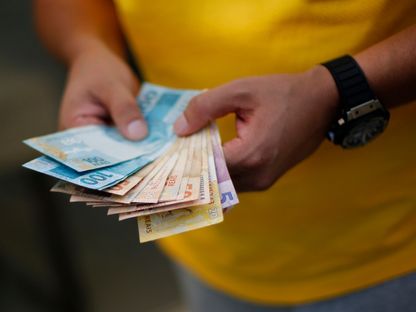 رجل يجمل أوراق نقدية في برازيليا - Reuters