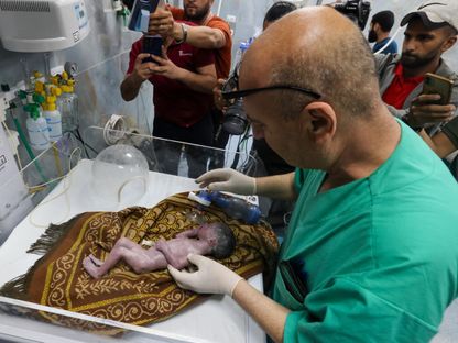 طبيب يعتني بطفلة فلسطينية رحلت أمها عقب ولادتها جراء إصابتها في قصف إسرائيلي على مدينة رفح بقطاع غزة. 20 أبريل 2024 - AFP