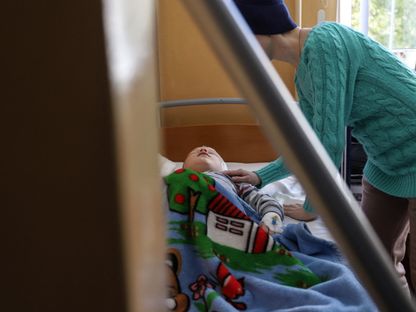 أم تعتني بطفلها المريض بسرطان الدماغ في أوكرانيا. 13 أبريل 2022 - AFP