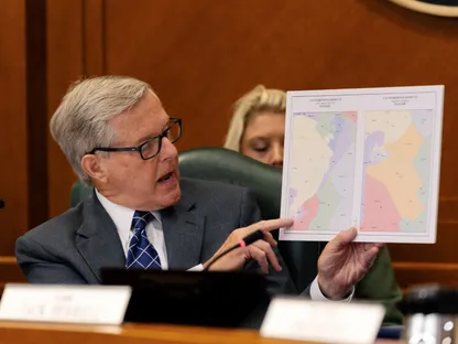 عضو مجلس الشيوخ في ولاية تكساس فيل كينج يرفع خريطة تُظهر دائرة انتخابية جديدة خلال جلسة إعادة تقسيم الدوائر الانتخابية في مبنى الكابيتول. 7 أغسطس2025 - reuters