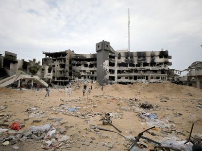 مسعفون يبحثون عن جثث داخل مستشفى الشفاء بغزة. 8 أبريل 2024 - REUTERS