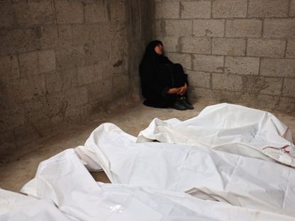 امرأة فلسطينية تجلس أمام جثث لأفراد أسرتها الذين قتلوا جرّاء قصف إسرائيلي على مدينة رفح جنوب قطاع غزة. 29 أبريل 2024 - AFP