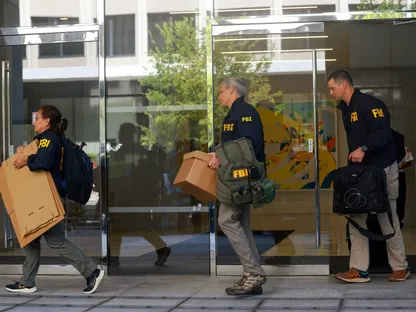 عملاء مكتب التحقيقات الفيدرالي (FBI) يحملون صناديق بعد مغادرة المبنى الذي يضم مكتب مستشار الأمن القومي الأميركي السابق جون بولتون بالعاصمة واشنطن. 22 أغسطس 2025 - REUTERS