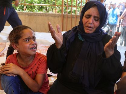 امرأة فلسطينية برفقة ابنتها تودع ابنها الذي قتلته إسرائيل أثناء محاولته الحصول على مساعدات في رفح جنوب قطاع غزة. 12 يوليو 2025 - Reuters