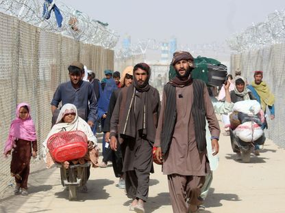 أفغان يسيرون داخل ممر مسيّج أثناء دخولهم باكستان عبر بلدة شامان الحدودية. 25 أغسطس 2021 - AFP