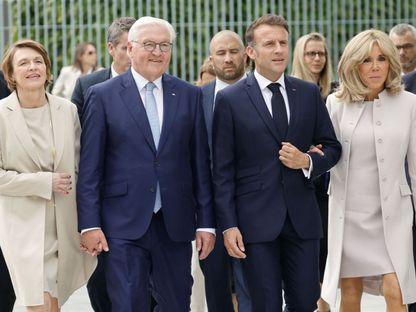 الرئيس الألماني فرانك فالتر شتاينماير وزوجته إلكه بويدنبندر يسيران مع الرئيس الفرنسي إيمانويل ماكرون وزوجته بريجيت ماكرون أمام المستشارية في طريقهما لحضور مناظرة كجزء من مهرجان الديمقراطية في برلين. 26 مايو 2024 - AFP