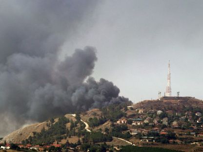 صورة التقطت من بلدة مرجعيون الحدودية بجنوب لبنان تظهر الدخان يتصاعد من منطقة بالجانب الإسرائيلي بعد استهدافه بصواريخ حزب الله. 14 يونيو 2024 - AFP