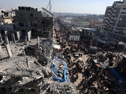فلسطينيون بين أنقاض المنازل والمباني التي دمرتها الضربات الإسرائيلية في مخيم النصيرات للاجئين بوسط قطاع غزة. 30 نوفمبر 2023 - Reuters