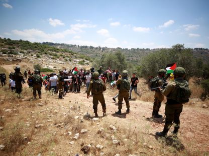 فلسطينيون يشاركون في مظاهرة ضد البناء الاستيطاني في قرية أم صفا في رام الله، الضفة الغربية. 7 يوليو 2023 - REUTERS