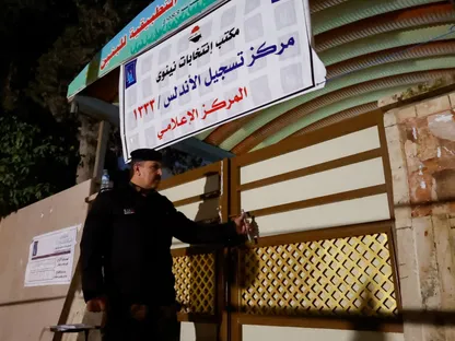 أحد عناصر الأمن يغلق مركز اقتراع بعد انتهاء عملية التصويت في انتخابات مجلس محافظة العراق، في الموصل، العراق. 18 ديسمبر 2023 - Reuters