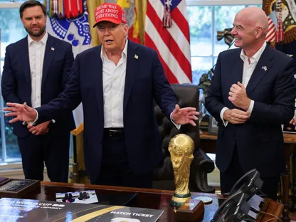 الرئيس الأميركي دونالد ترمب يتوسط نائبه جي دي فانس ورئيس الاتحاد الدولي لكرة القدم جياني إنفانتينو في البيت الأبيض. 22 أغسطس 2025 - Reuters