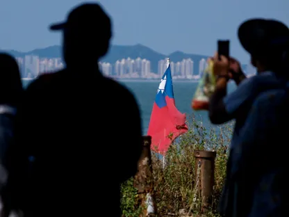 علم تايوان في أحد سواحل الجزيرة وفي الخلفية مدينة شيامن في البر الرئيسي للصين. ، 18 أكتوبر 2025 - Reuters