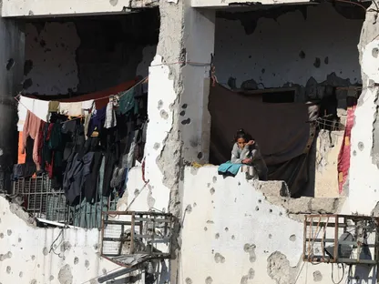 امرأة فلسطينية تنظر من مبنى متضرر في مدينة غزة، فلسطين. 2 ديسمبر 2025 - REUTERS