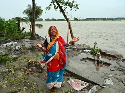 سيدة تقف إلى جانب منزلها الذي جرفته السيول جراء فيضان نهر بادما في بنجلاديش. 13 سبتمبر 2022 - AFP