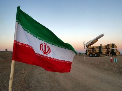 العلم الإيراني بالقرب من قاذفة صواريخ خلال مناورة عسكرية في إيران. 19 أكتوبر 2020 - REUTERS