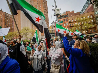 سوريون أمام مقر الأمم المتحدة في نيويورك خلال فعالية رفع العلم السوري الجديد. 25 أبريل 2025 - Reuters