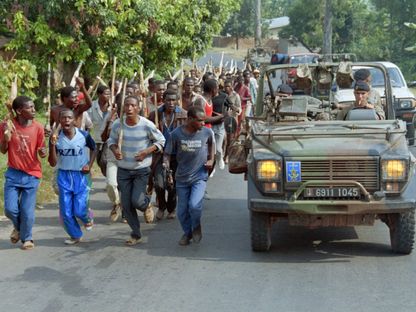 جنود فرنسيون خلال دورية يمرون أمام قوات الهوتو في رواندا. 27 يونيو 1994 - AFP