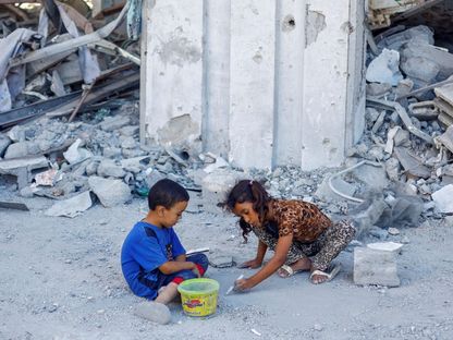 أطفال فلسطينيون يلعبون خارج أنقاض منزل دمرته غارات إسرائيلية في خان يونس جنوب قطاع غزة. 11 سبتمبر 2024 - REUTERS