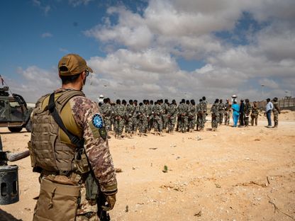 جندي من بعثة تدريب الاتحاد الأوروبي في الصومال (EUTM-S) يراقب إحاطة صباحية عقدت لقوات الجيش الصومالي (SOCAC) في مركز تدريب الجنرال دجابادان في مقديشو، 19 مارس 2024 - AFP