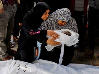 جدة رضيع فلسطيني تحتضن حفيدها الذي وُلد خلال الحرب الإسرائيلية على غزة وقتلته غارة إسرائيلية في رفح بجنوب القطاع. 12 ديسمبر 2023 - Reuters