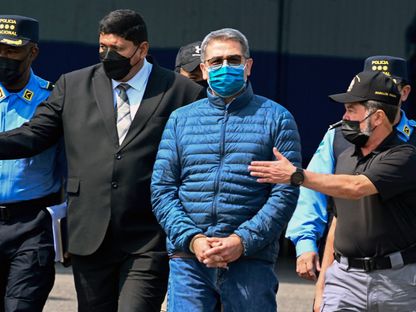 رئيس هندوراس السابق خوان أورلاندو هيرنانديز يتجه نحو طائرة تابعة لوكالة مكافحة المخدرات الأميركية DEA خلال تسليمه إلى الولايات المتحدة من قاعدة جوية في تيجوسيجالبا. 21 أبريل 2022 - AFP