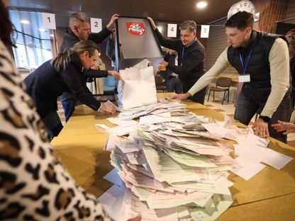 أعضاء لجنة انتخابية محلية يعدون أوراق الاقتراع في مركز اقتراع بالعاصمة فيلنيوس خلال الجولة الأولى من الانتخابات الرئاسية في ليتوانيا. 12 مايو 2024 - AFP