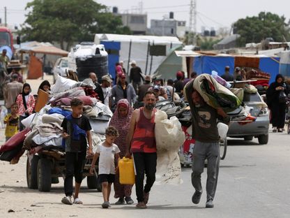 نازحون فلسطينيون يغادرون رفح سيراً على الأقدام ومعهم أمتعتهم بسبب الغارات الإسرائيلية، جنوب قطاع غزة. 28 مايو 2024 - reuters