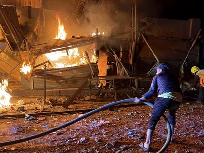 فلسطينيون يحاولون إطفاء حريق بعد غارة إسرائيلية على مدرسة تؤوي نازحين في مخيم البريج وسط قطاع غزة. 6 مايو 2025 - Reuters