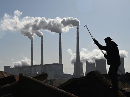 عامل بالقرب من محطة لتوليد الطاقة باستعمال الفحم الحجري في زانغجياكو بالصين. 12 نوفمبر 2021 - AFP