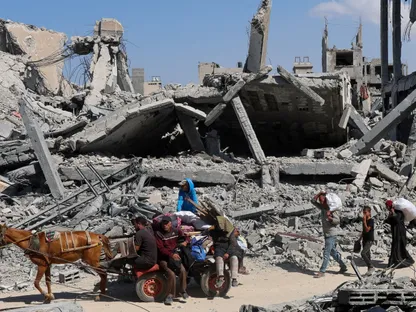 فلسطينيون يمرون بجوار الأنقاض بعد انسحاب القوات الإسرائيلية من خان يونس جنوب قطاع غزة. 10 أكتوبر 2025 - REUTERS