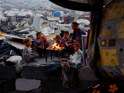 رجل فلسطيني وأطفال يحتمون بخيمة وسط أنقاض منازل مدمرة في جباليا، شمال قطاع غزة. 6 نوفمبر 2025 - رويترز