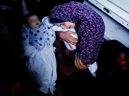 والدة التوأم الفلسطيني وسام ونعيم أبو عنزة تعانق الطفلين اللذين ولدا خلال حرب غزة وقتلتهما غارات إسرائيلية في رفح جنوب قطاع غزة. 3 مارس 2024 - Reuters