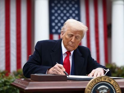 الرئيس الأميركي دونالد ترمب يوقع أمراً تنفيذياً خلال إعلان رسوم جمركية في البيت الأبيض بواشنطن. 2 أبريل 2025 - Bloomberg
